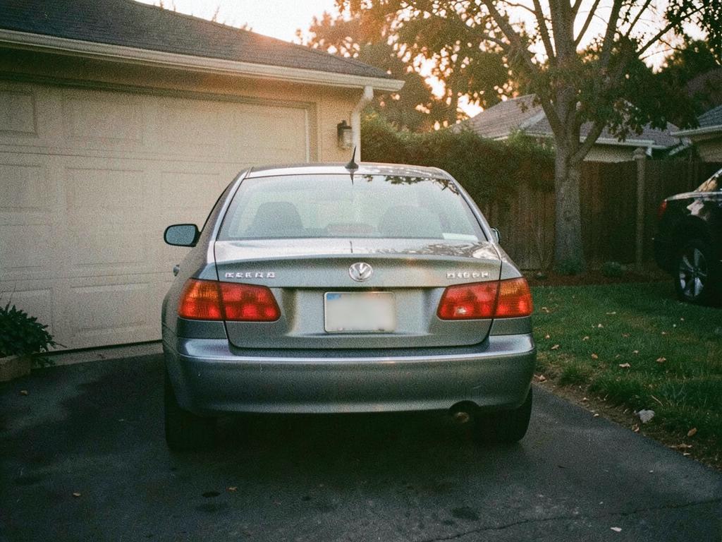 A sedan parked in a driveway at golden hour